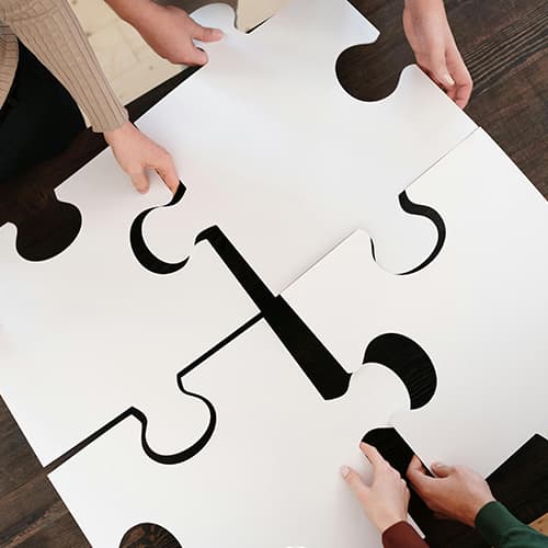Mentorprogram puzzle darabok fehér kartonból amiket emberek illesztenek egybe